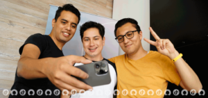 tres hombres trabajando en Devoteam tomandose una foto con un celular iphone